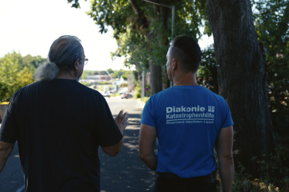 Fluthelfer der Diakonie im Gespräch mit einem Geschädigten