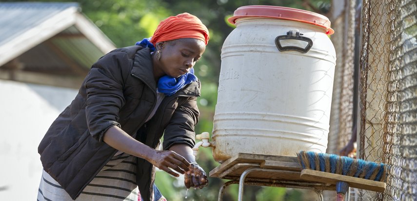 Eine Frau desinfiziert sich die Hände mit chlorhaltigem Wasser.